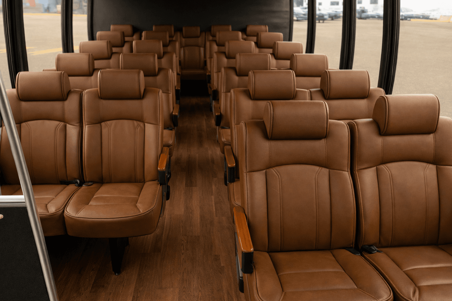 Center aisle and rows of high-back reclining seats inside an eighteen passenger coach